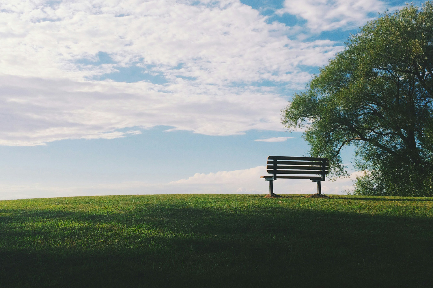 empty chair on grassy hill funeral celebrant
